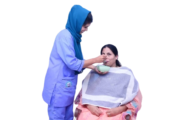 Nurse feeding an elderly woman at home.